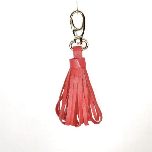 Borsa gioiello con pompon in pelle di agnello di colore rosso-arancio.