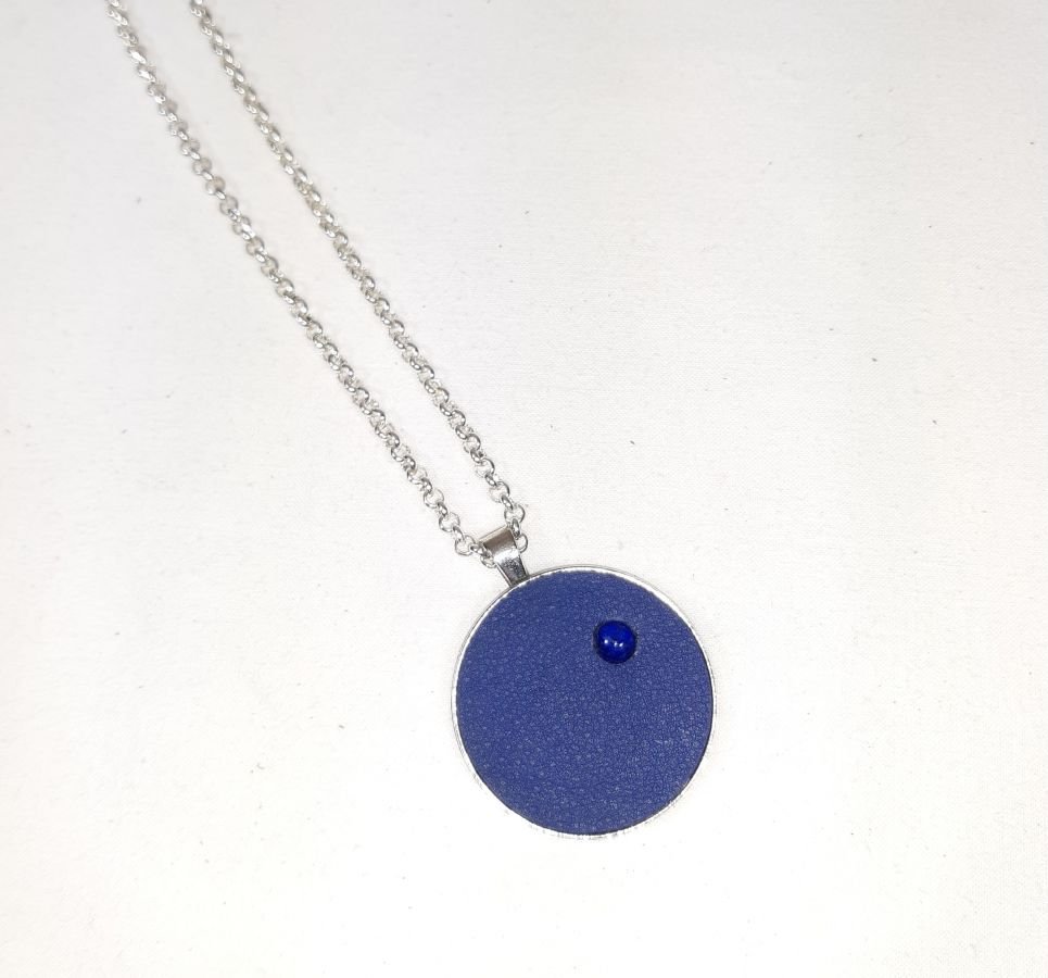 Ciondolo in ottone e pelle blu con lapislazzuli cabochon.